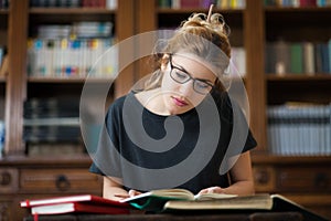 Female student in a library reading on a desktop