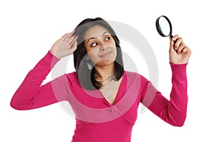 Female student looking through a magnifying glass