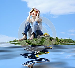 Female student outdoor on green grass with books