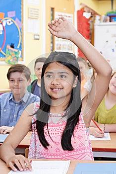 Female Student Raising Hand To Answer Question On Class