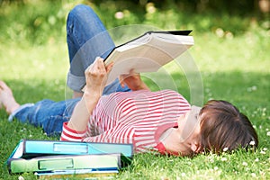 Female Student Reading Textbook In Park