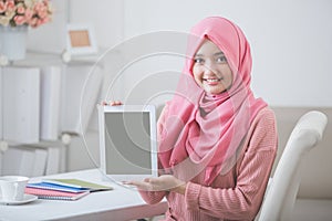 Female student showing tablet screen and smile to camera