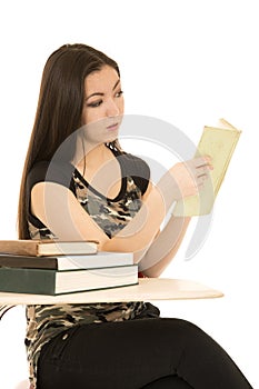 Female student sitting at her desk reading book