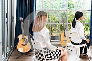 female student sitting taking notes music teacher