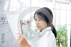 female student sitting taking notes music teacher