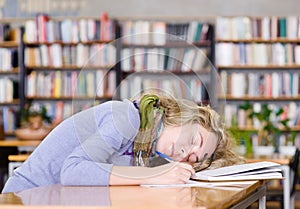 Female student sleeping in a university library