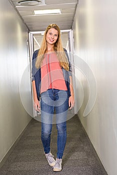 Female student standing at college corridor