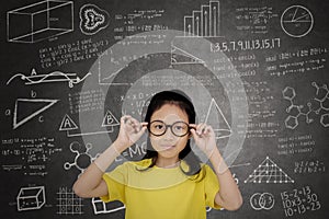 Female student standing with mathematics formula