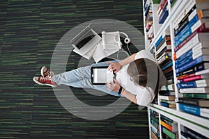 Female student study in library, using tablet and searching for