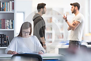 female student study in school library, group of students in background