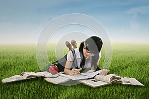 Female student studying on grass 1