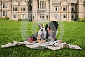 Female student studying on grass