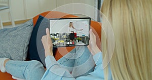 A female student takes an extra lesson distance. Video chat between student and teacher. Over shoulder tabletPC blur photo