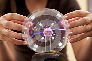 Female student touching a plasma ball.