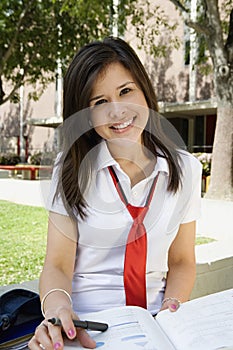 Female Student In Uniform Studying