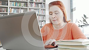Female student using her laptop at college library