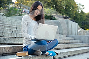 Female student using laptop computer outdoors