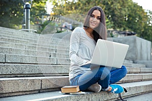 Female student using laptop computer outdoors