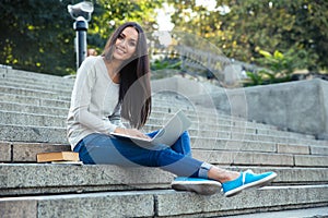 Female student using laptop computer outdoors