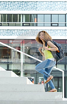 Female student walking up stairs to college