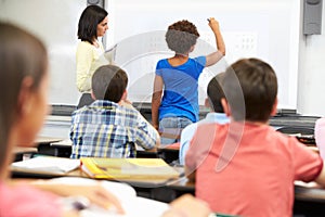 Female Student Writing Answer On Whiteboard