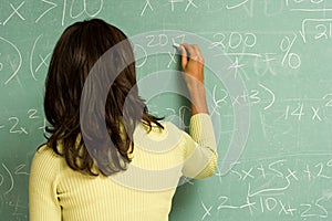 Female student writing on blackboard