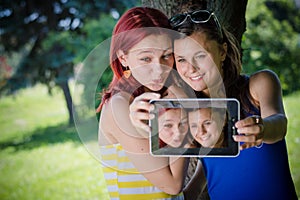 female students in park with tablet pc