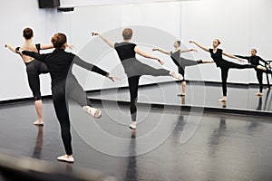 Female Students At Performing Arts School Rehearsing Ballet In Dance Studio Reflected In Mirror