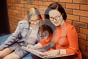 Female students sit in the corridor of the university / university dormitory and teach homework, lectures. The girl explains to