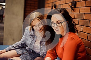 Female students sit in the corridor of the university / university dormitory and teach homework, lectures. The girl explains to