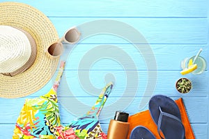 Female summer beach accessories hat, swimsuit, sunscreen, sunglasses, hat, flip flops and earphones flat lay, top view, copy space