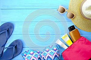 Female summer beach accessories swimsuit, sunscreen, sunglasses, hat, flip flops flat lay, top view, copy space. Beach summer fash