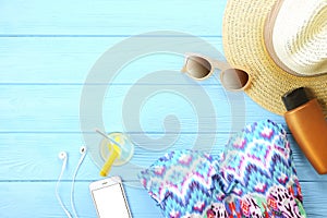 Female summer beach accessories swimsuit, sunscreen, sunglasses, hat, flip flops flat lay, top view, copy space. Beach summer fash photo