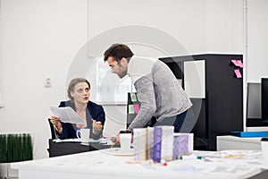 A female supervisor explaining something to a guy from her staff