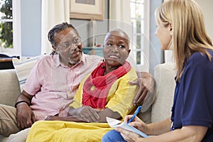 Female Support Worker Visits Senior Couple At Home