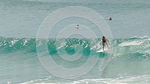 Female surfer riding a wave on their backhand at greenmount, qld