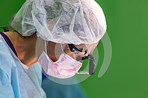 Female surgeon doctor wearing protective mask and hat during the operation. Healthcare, medical education, emergency