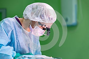 Female surgeon doctor wearing protective mask and hat during the operation. Healthcare, medical education, emergency