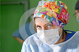 Female surgeon doctor wearing protective mask and hat during the operation. Healthcare, medical education, emergency