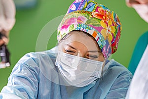 Female surgeon doctor wearing protective mask and hat during the operation. Healthcare, medical education, emergency