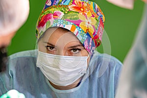 Female surgeon doctor wearing protective mask and hat during the operation. Healthcare, medical education, emergency