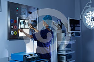 Female surgeon examining x-ray on a light box in the hospital