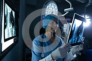 Female surgeon examining x-ray in operating room of hospital