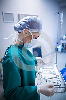 Female surgeon holding surgical tray in operation theater