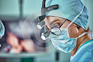 Female surgeon in operation room with reflection in glasses photo