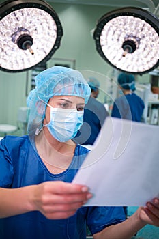 Female surgeon reading report in operation room