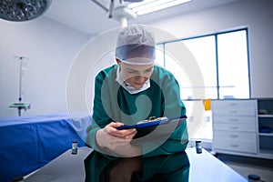 Female surgeon reading reports in operation theater