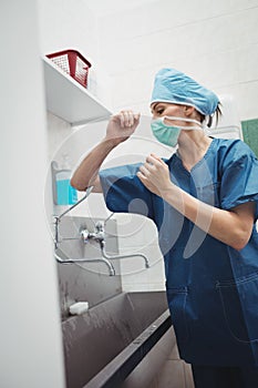Female surgeon washing hands prior to operation using correct technique for cleanliness