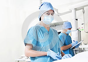 Female surgeon working in the operating room, looking at camera