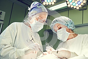 Female surgeons operating child in clinics